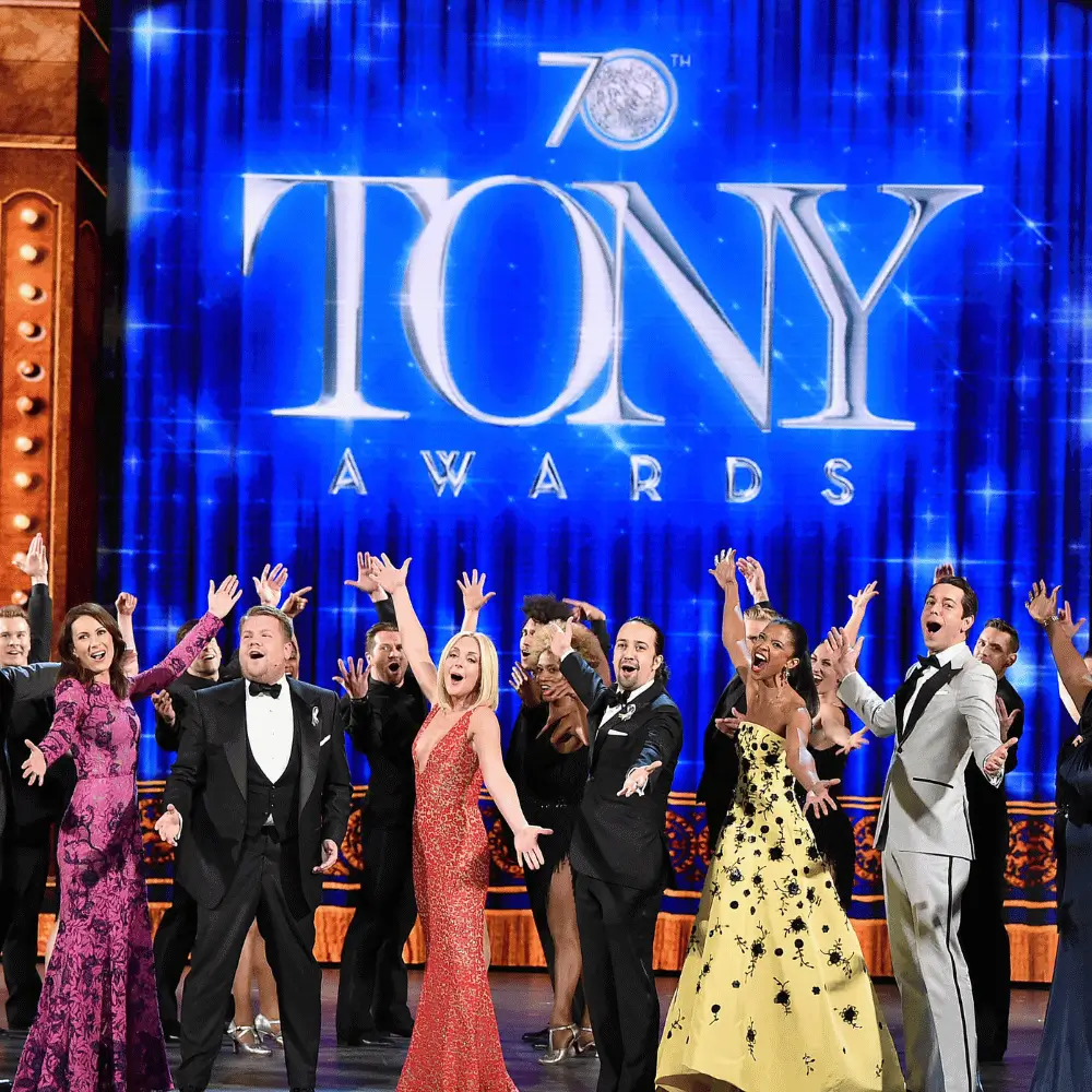 The cast of the 70th Tony Awards performing beneath the Tony Awards emblem